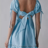 Light blue dress with cut-out back and tie detail on a gray background